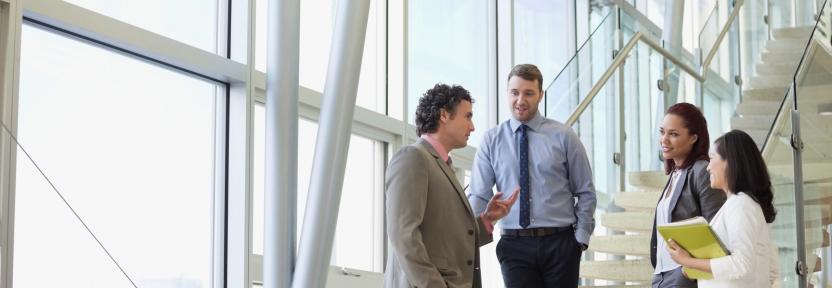 Business colleagues talking while standing by stairway